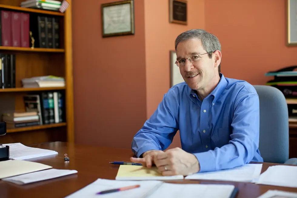 Framed certificates and shelves of bound reporters behind a partner's desk